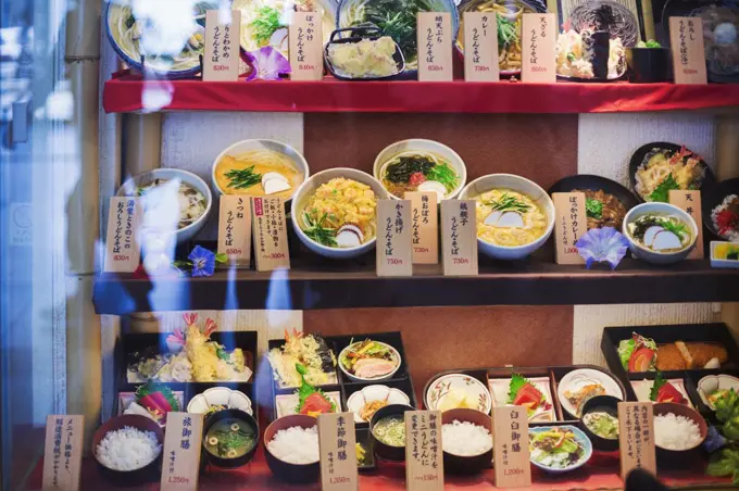 High angle view of a selection of bowls with traditional Japanese foods on shelves.