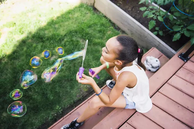 Tween Girl Blowing Bubbles in the Backyard