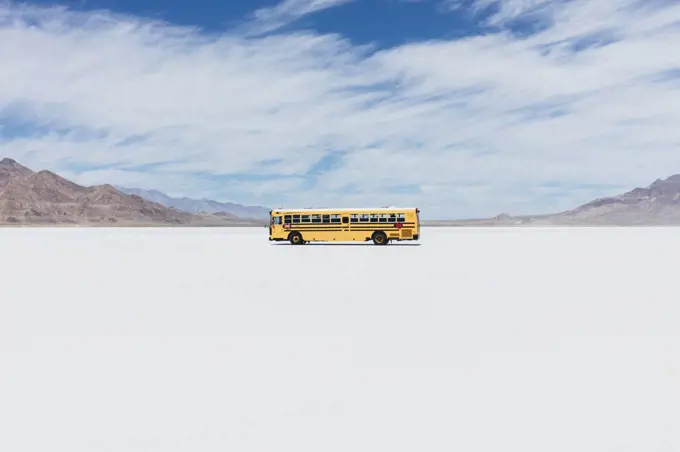 Yellow school bus driving on Salt Flats 