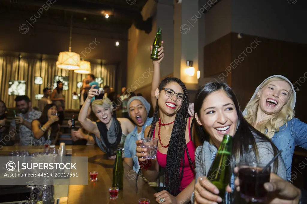Enthusiastic friends cheering at bar