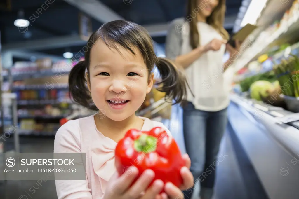Portrait of smiling girl holding red bell pepper