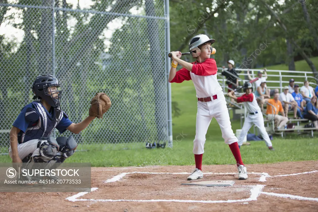 Young male baseball player ready to bat at home.