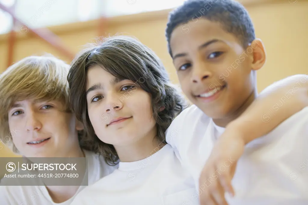 three male teenage students posing in gymnasium
