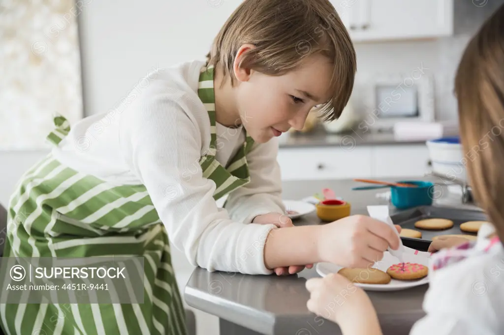 Boy decorating cookies in kitchen