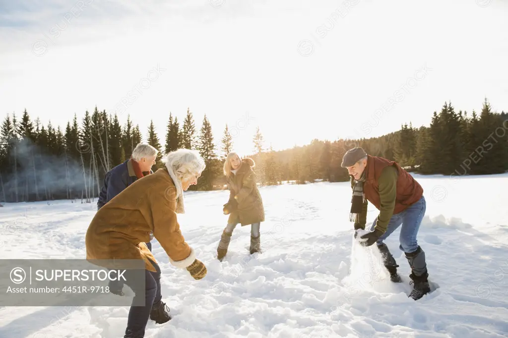 Mature friends having a snowball fight