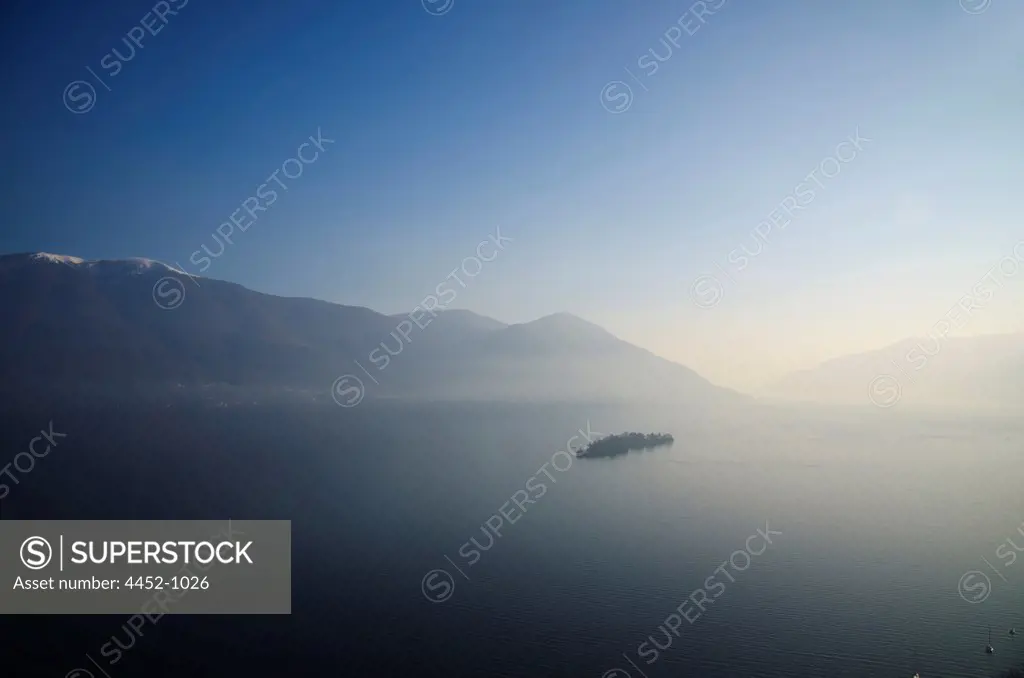 Aerial View over Brissago Islands on an Alpine Lake Maggiore with Mountains and Fog with Sunlight in Ticino, Switzerland.
