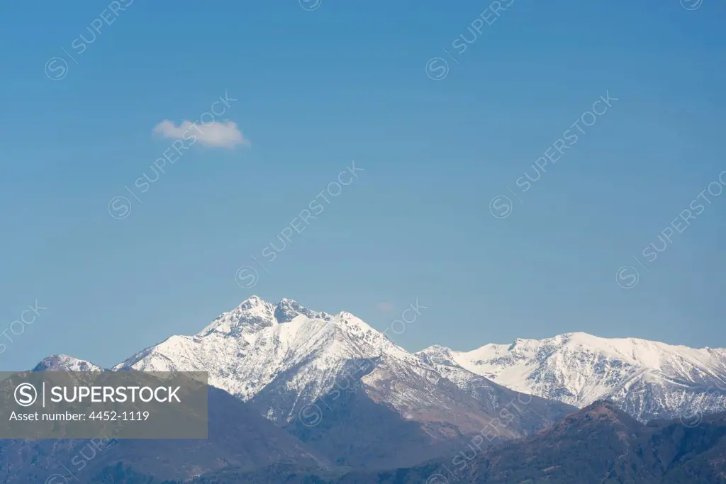 Snow-capped Mountain and One Cloud on Blue Sky in Locarno, Switzerland.