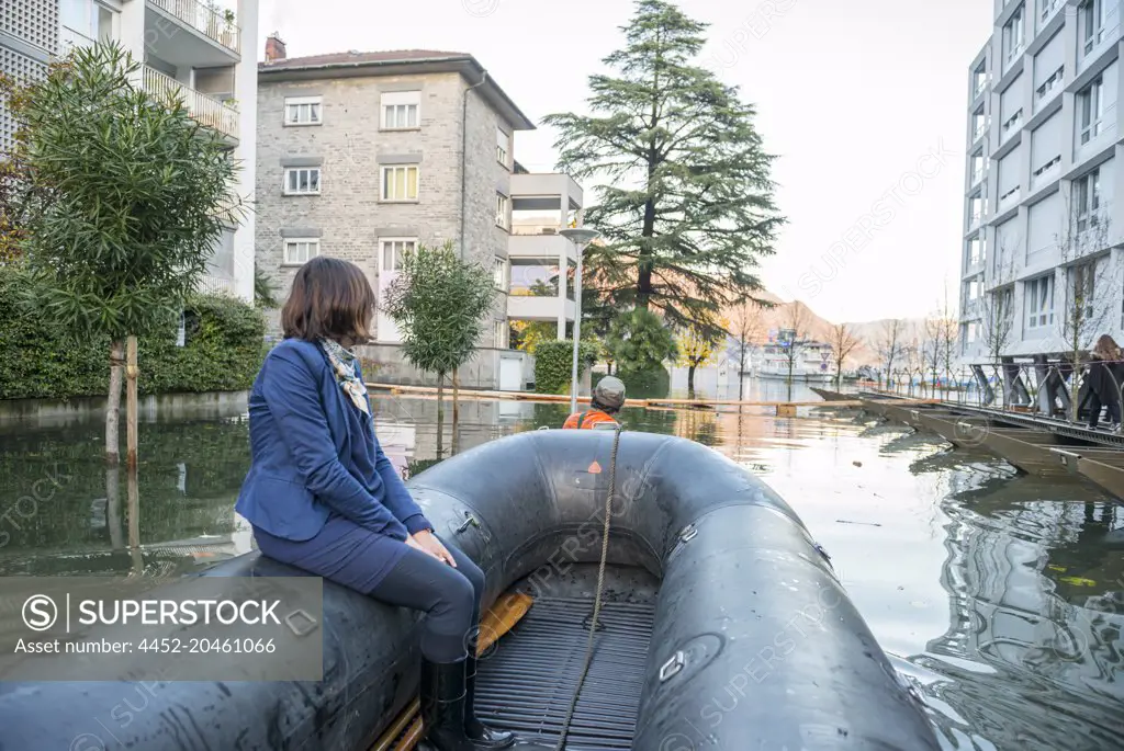 Woman Travel in a Rescue Boat in City of Locarno on Flooding Street in Ticino, Switzerland.
