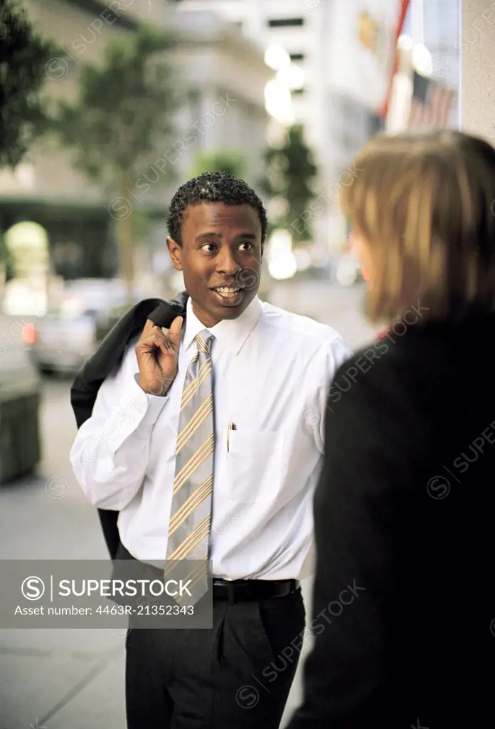 Businessman and woman talking in the street. 