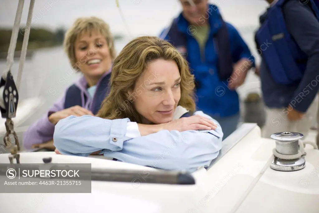 Mature adult woman relaxing on a boat with friends.