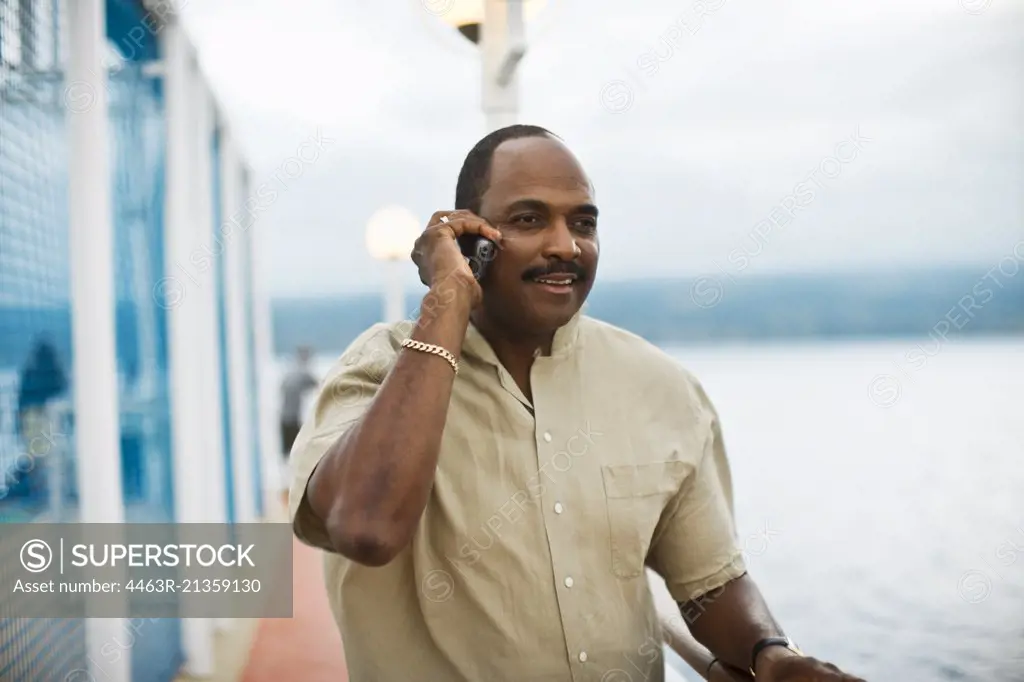 Man talks on a cell phone on a pier.