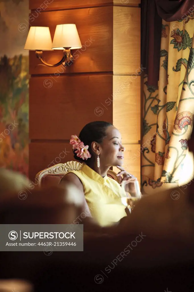 Woman relaxing with a glass of wine at an upscale restaurant.