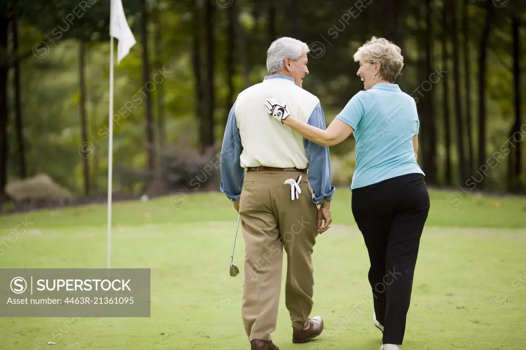 Older couple sharing a laugh on a golf course