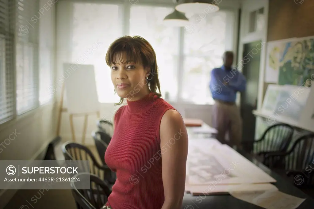 Portrait of a mid-adult woman in a meeting room.