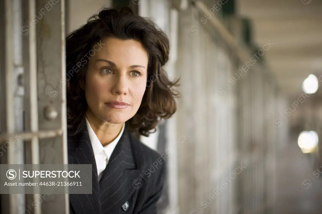 Mid-adult business woman inside a cell of a derelict building