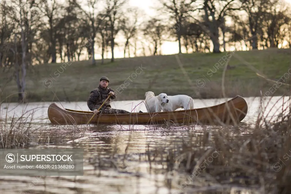 Hunter sitting in a canoe with his two dogs