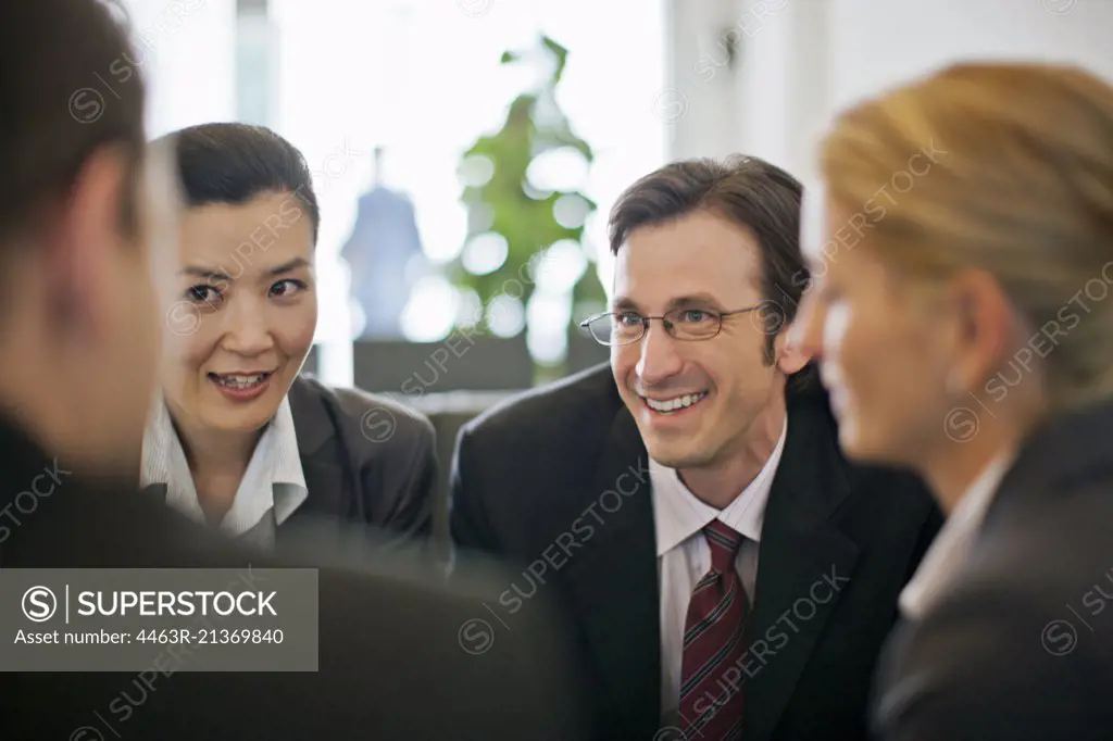 Group of business colleagues conversing in a board room.