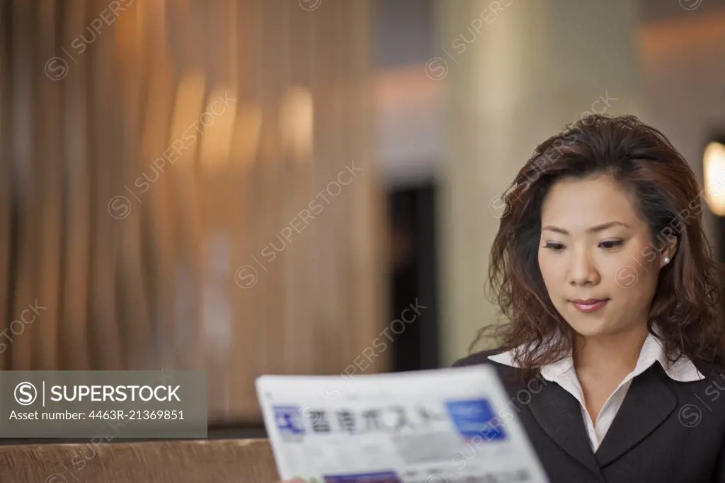 Businesswoman reading a newspaper in her office.