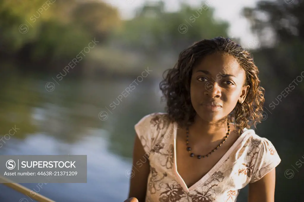 Portrait of a mid-adult woman standing by a river.