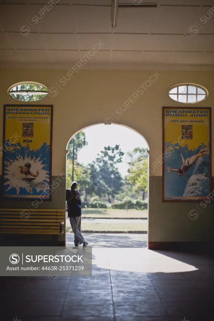 Boy standing in an archway of a building.