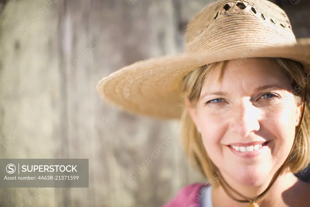 Portrait of a smiling mid-adult woman wearing a sunhat.
