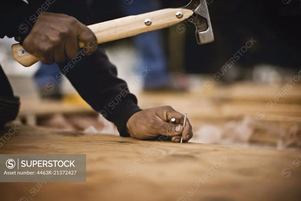Construction worker hammering in nails