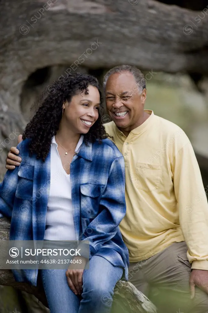 Couple sitting together on tree trunk