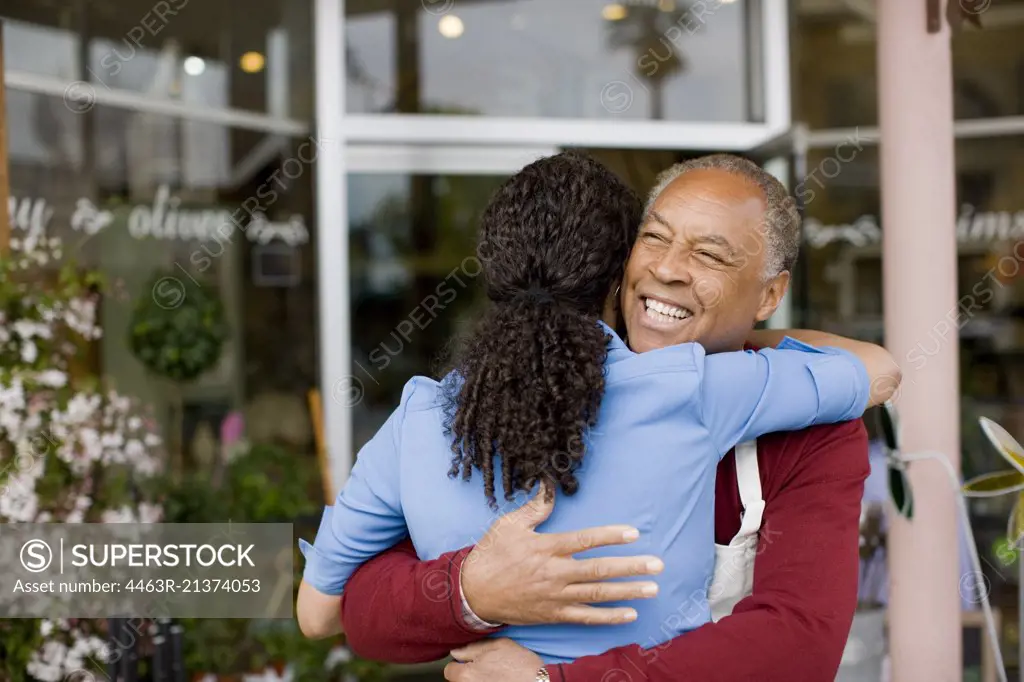 Man and woman hugging outside store