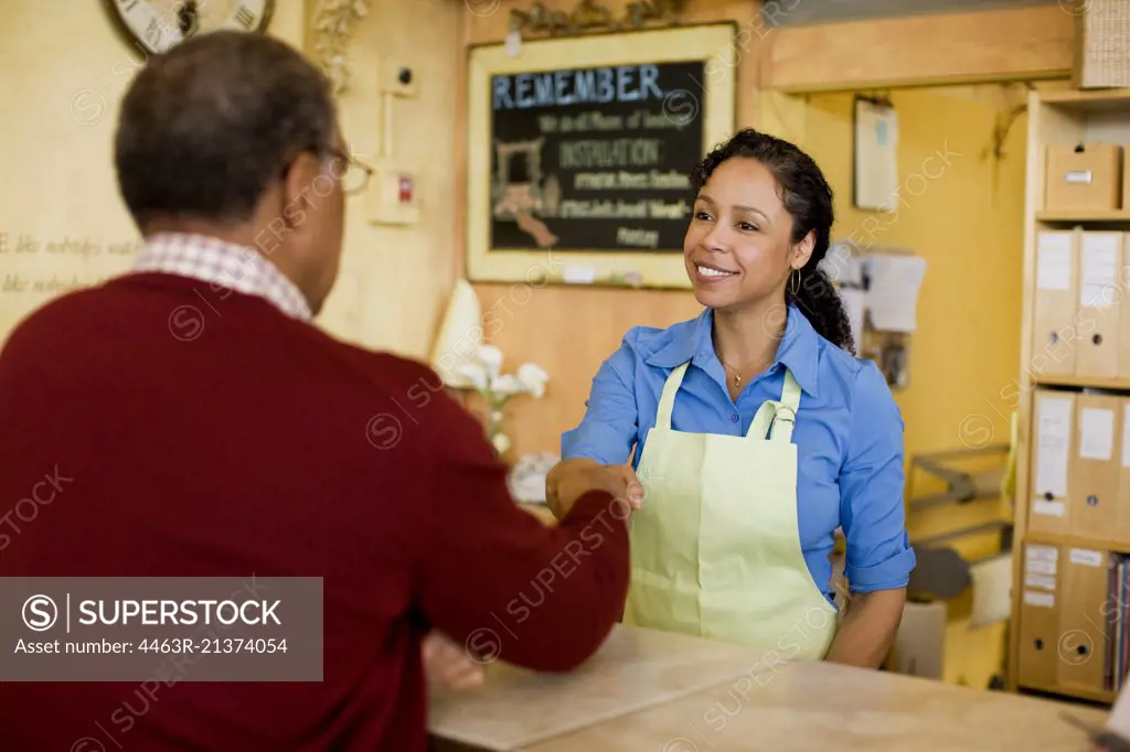 Sales clerk shaking hands with customer
