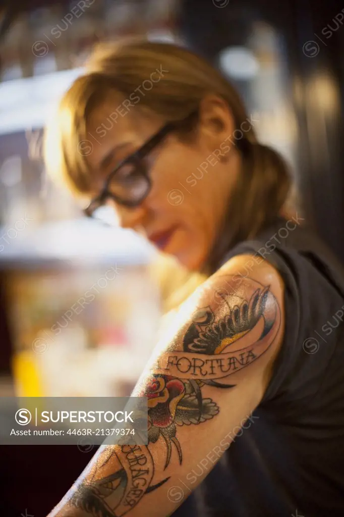 Portrait of woman with a fresh tattoo on her arm. 
