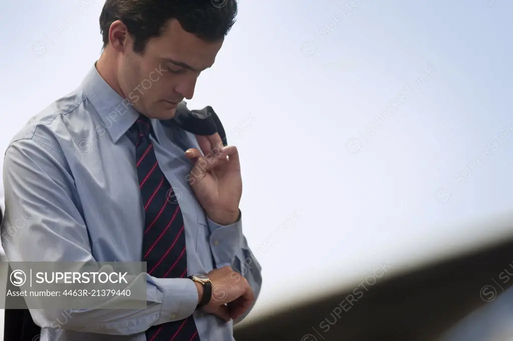 Businessman checks the time on his wristwatch.