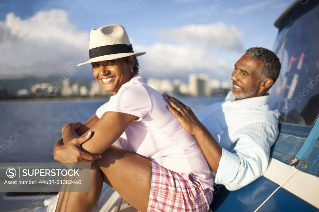 Mature couple lying back, relaxing on boat. 