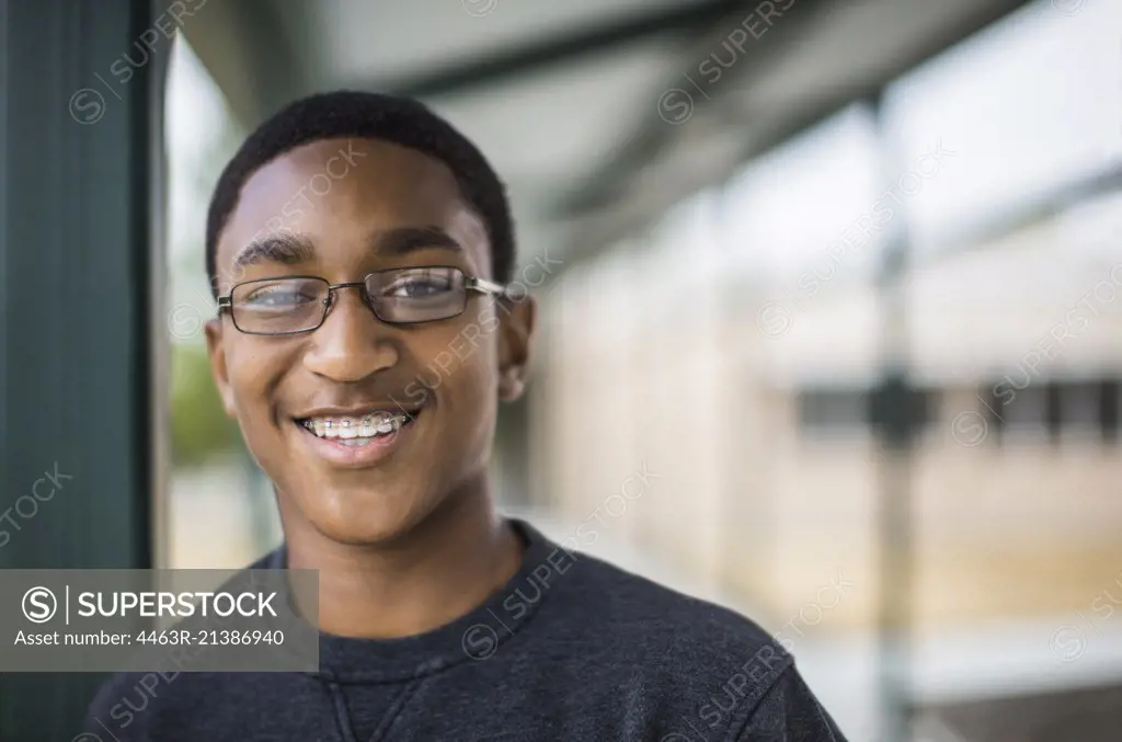 Portrait of teenage boy smiling at school.