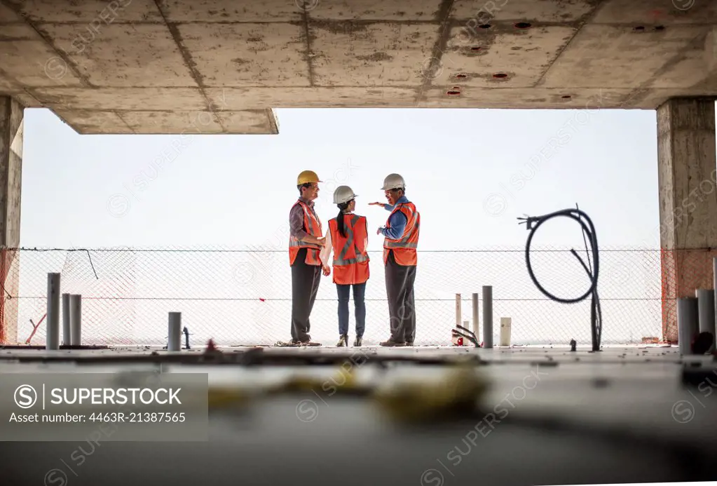 Three people on construction site.