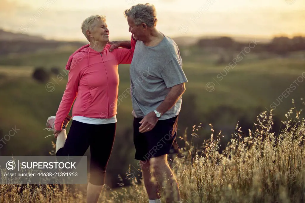 Mature woman and senior man warming up with stretches before going for a run.