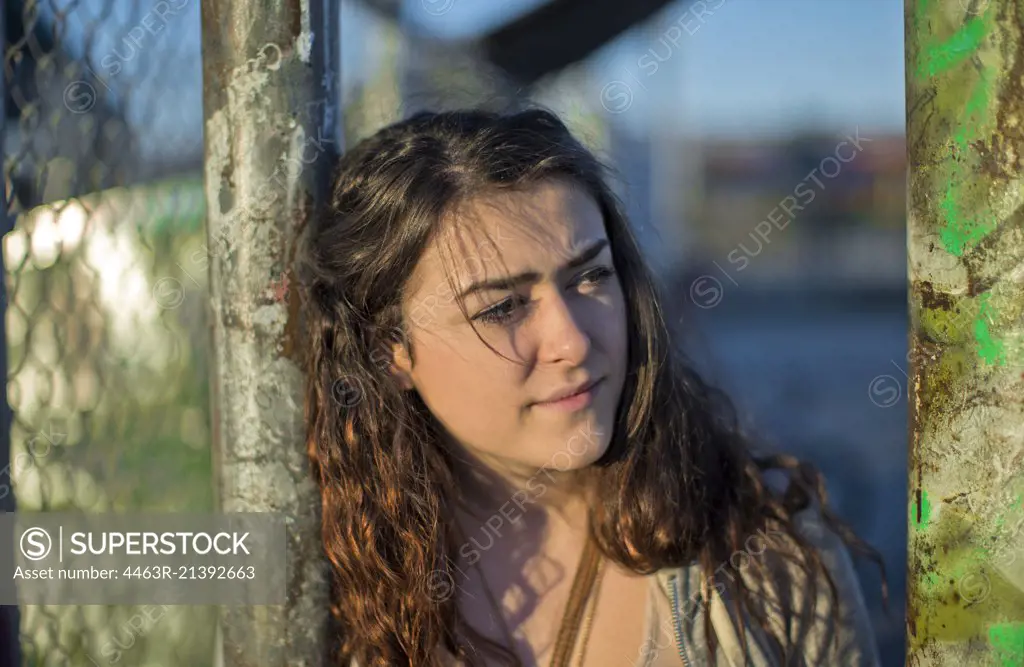 Woman leans against a fence