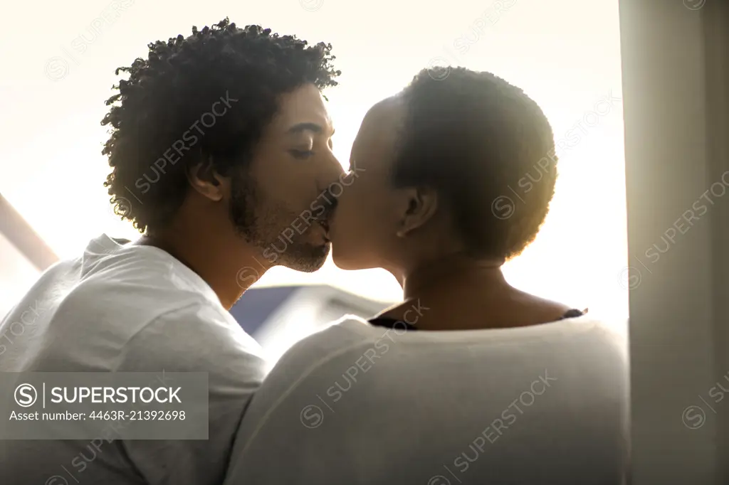 Happy young couple sharing a kiss.