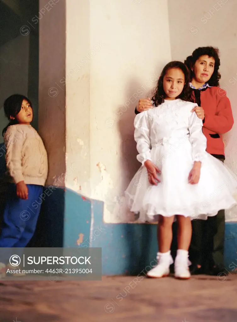 Peruvian girl in white dress with mother