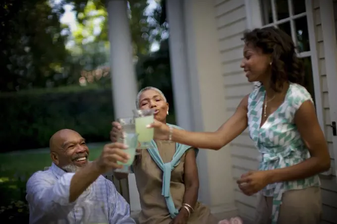Mature couple sharing a toast with their daughter.