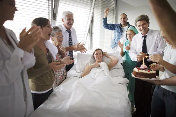 View of a family and doctors celebrating with a cake.