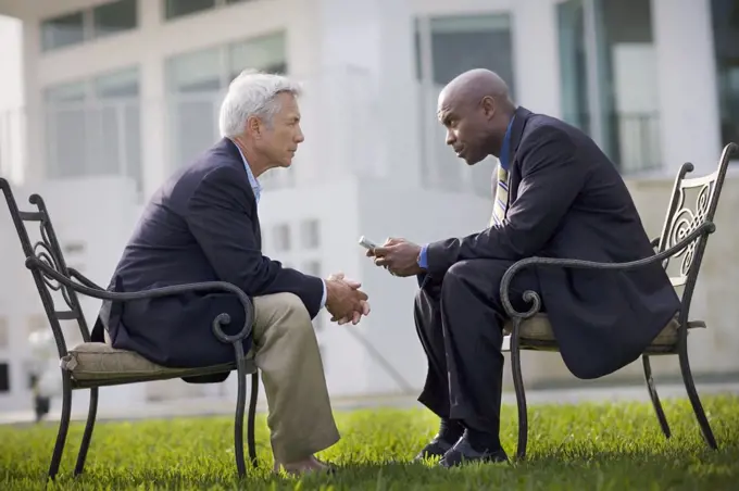 Two businessmen having a discussion outside.
