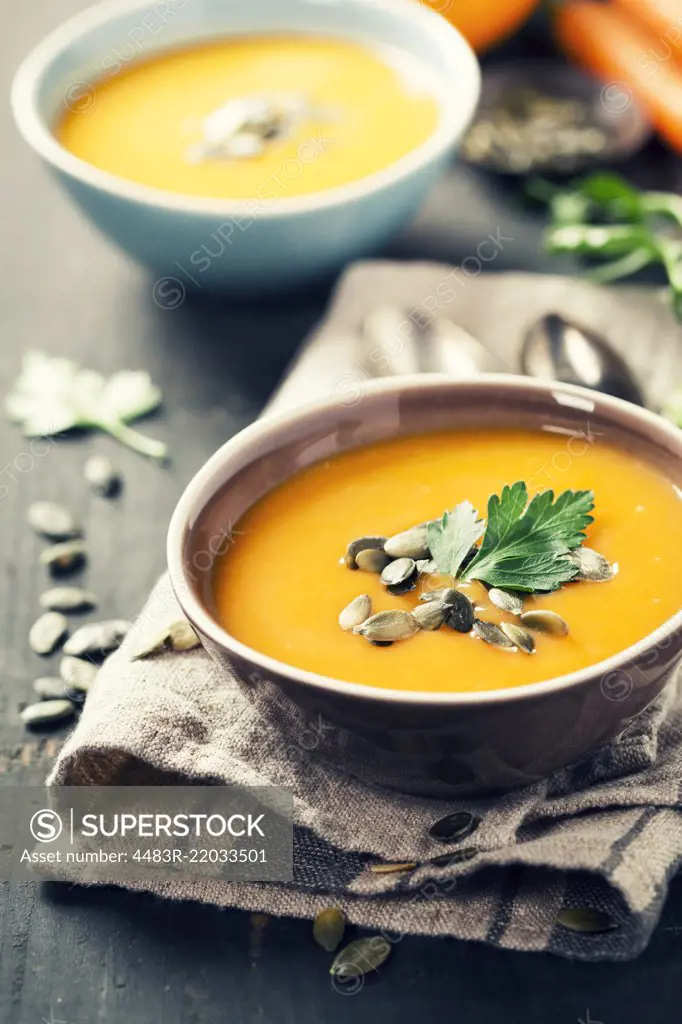 Pumpkin soup in a bowl on a wooden surface