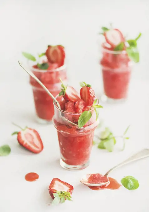 Healthy low calorie summer treat. Strawberry and champaigne granita, slushie or shaved ice dessert in glasses with mint, white background. Clean eating, vegan, dieting food concept