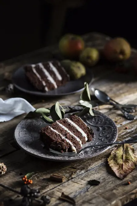 Autumn mood: slices of chocolate & pear cake on wooden table