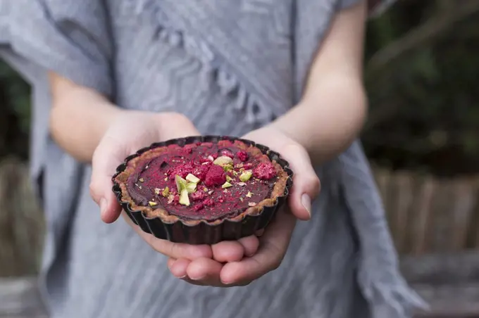 Spiced Chocolate Tarts being held in a girls hands