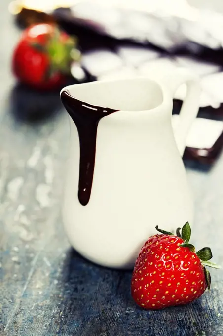 Delicious rich and thick chocolate sauce in a jug and assorted chocolates - food and drink