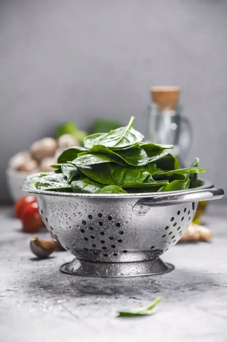 Spinach. Fresh organic spinach leaves in metal colander and healthy ingredients. Diet, dieting concept. Vegan food, healthy eating.