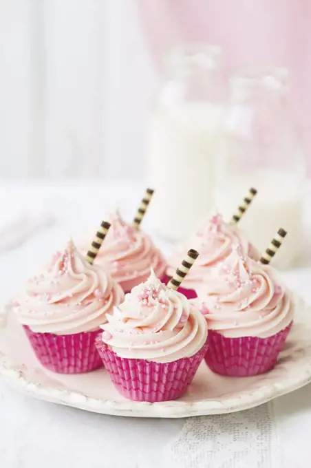 Pink cupcakes decorated with stripey chocolate straws