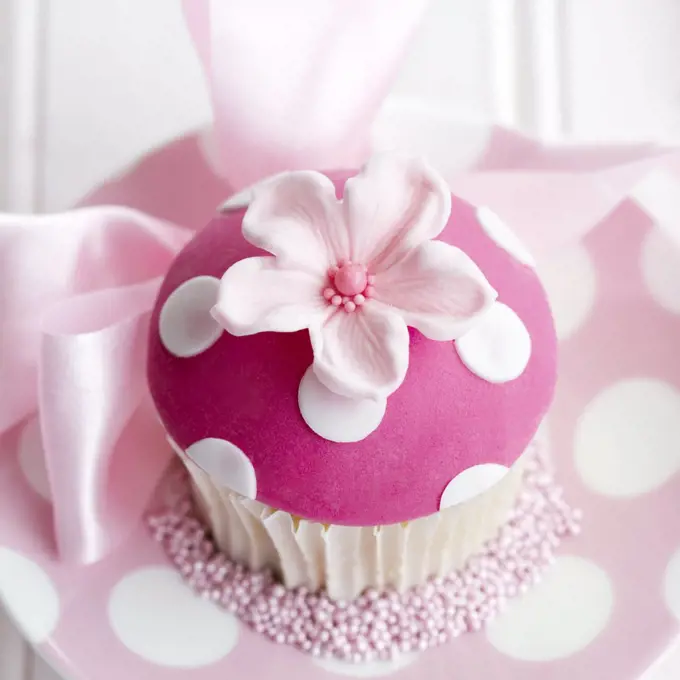Cupcake decorated with a pink fondant flower