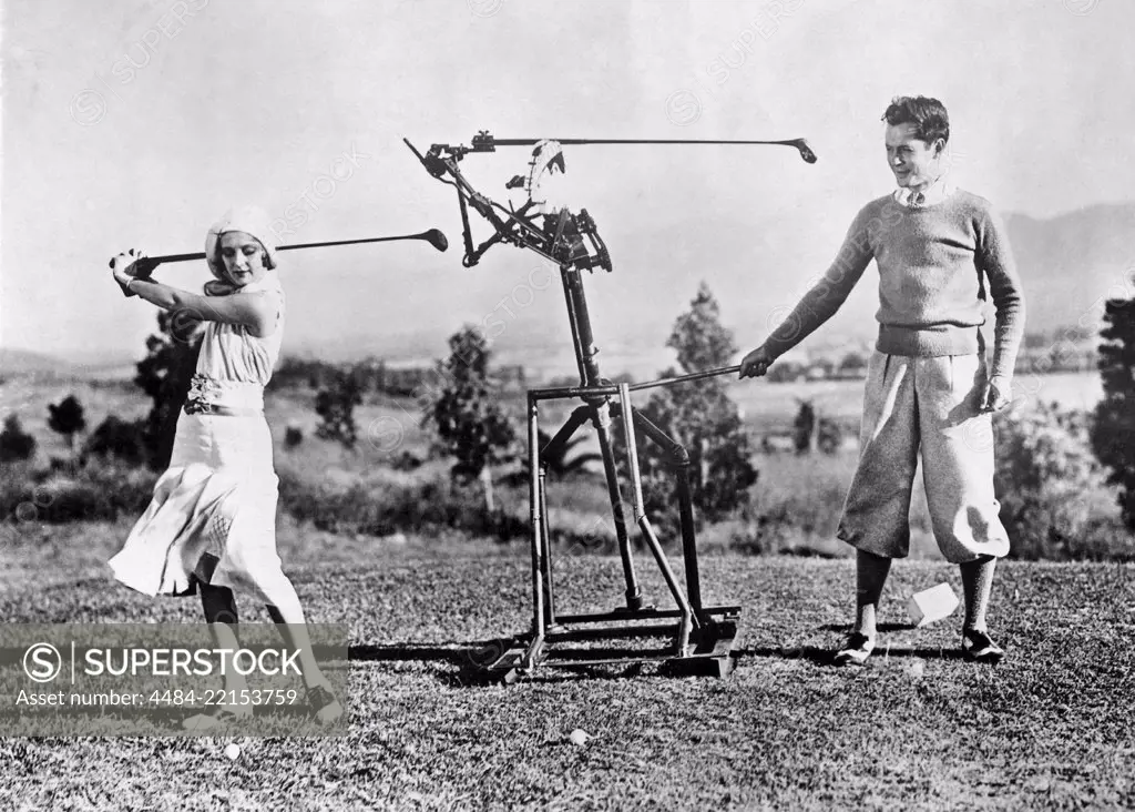 Woman learning to play golf in the 1930s. A young woman gets help from a robot golf instructor to perfect her swing. 